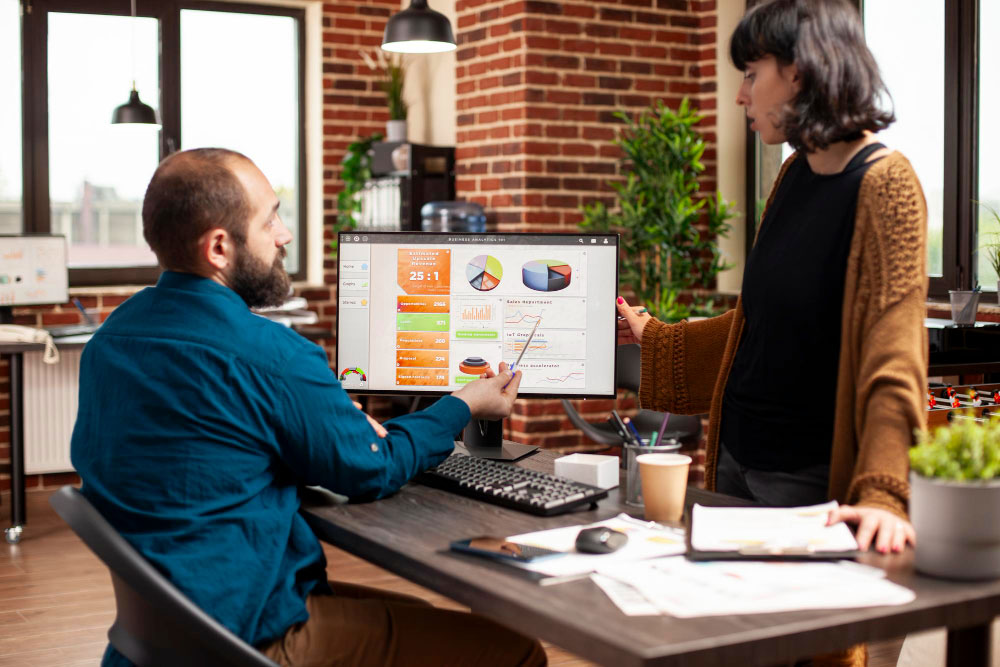 man shows crm stats to colleague